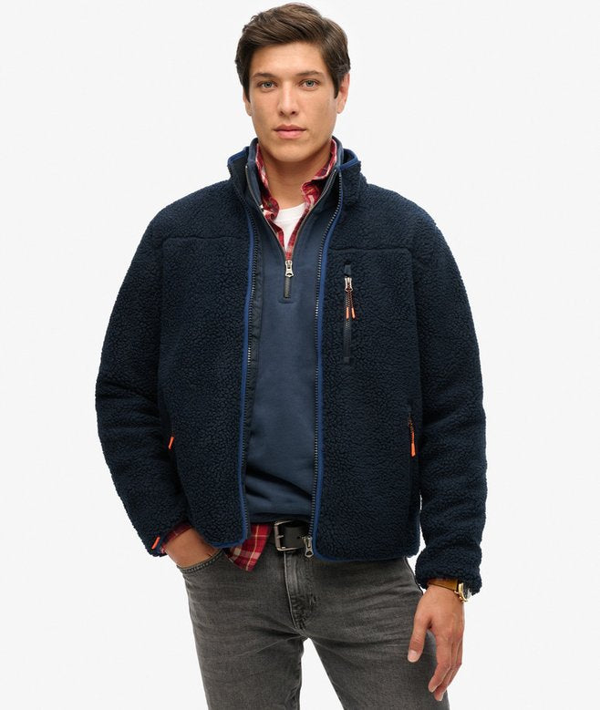 Man wearing a navy fleece jacket on a white background Superdry