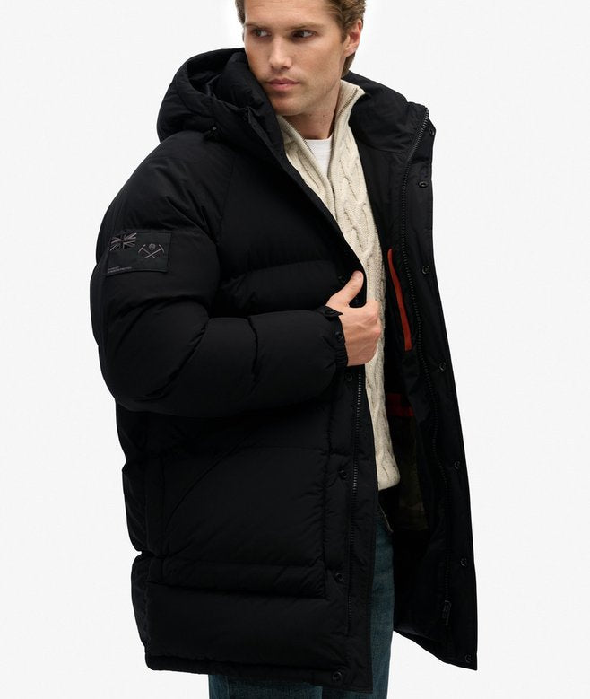 Man wearing a black puffer jacket on a white background
